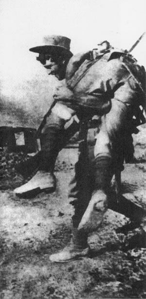 Photograph of a man carry another man through battle